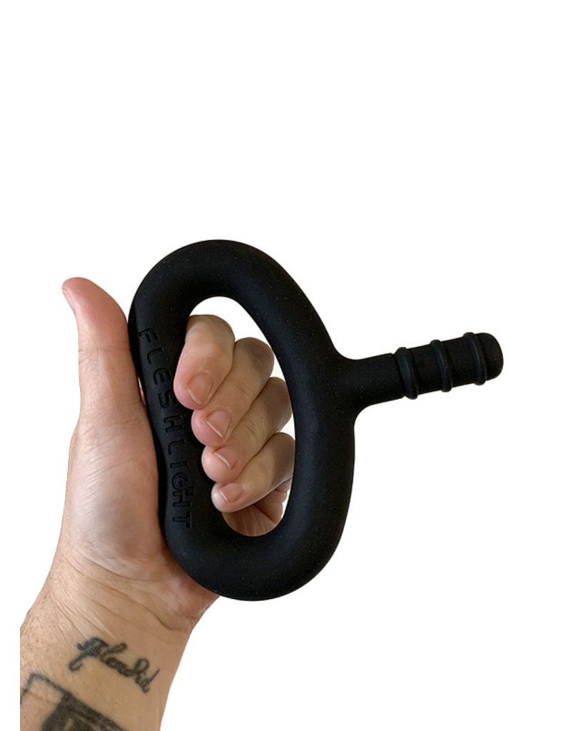 A black silicone oval handle held by a white tattooed person's hand.