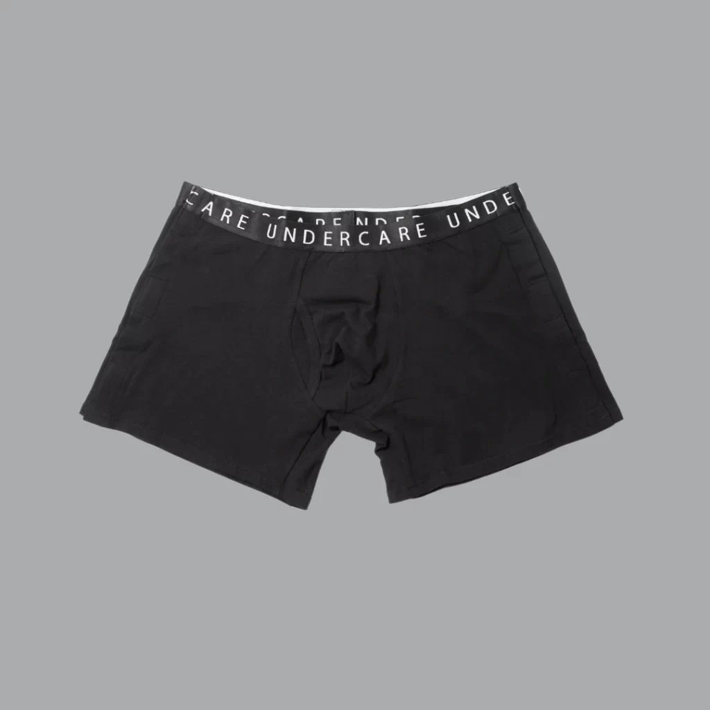 A pair of black boxers sits on a grey background. They have a black waistband. Undercare is written on the band. 